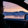 a man driving a car on a snowy road