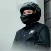 a man wearing a helmet standing next to a building
