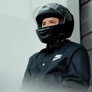 a man wearing a helmet standing next to a building