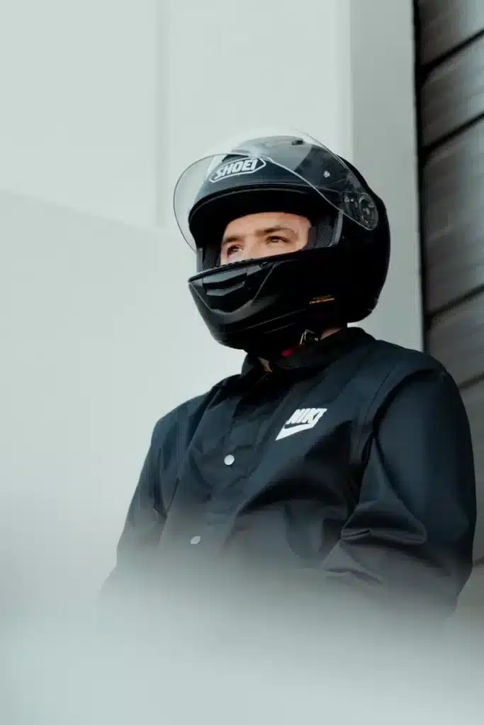 a man wearing a helmet standing next to a building