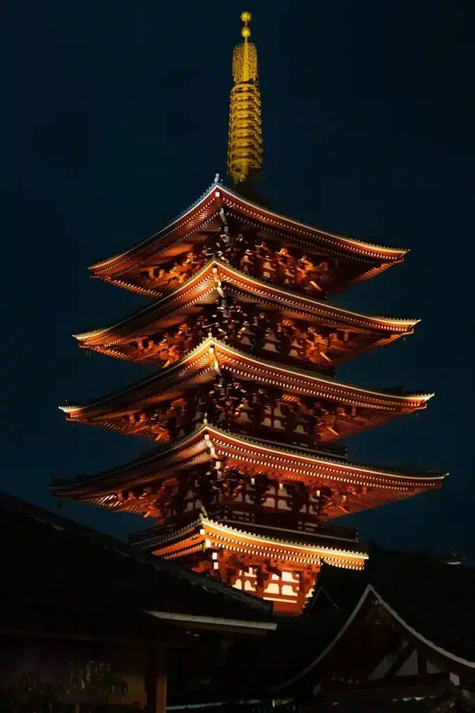 a tall building lit up at night with a sky background